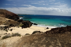 Playa de Los Conejos - а вот это по канарским понятиям настоящий пляж. Защищен от ветра черными базальтовыми скалами. В  отлив обнажаются пещерки и углубления, вход пологи песчаный, в небольшой лагунке относительно спокойная вода