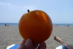 Сочный апельсин, купленный в одном из магазинов Тенерифе, очень к месту на пляже.